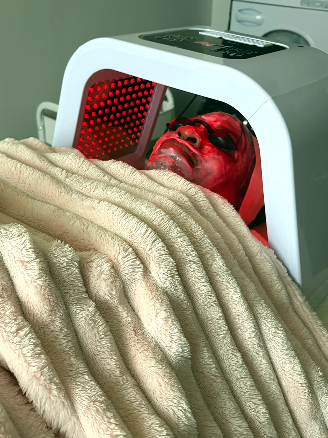 Client relaxing under red LED light therapy